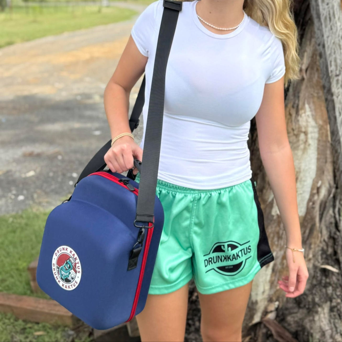 Model carrying trucker cap case with shoulder strap outdoors