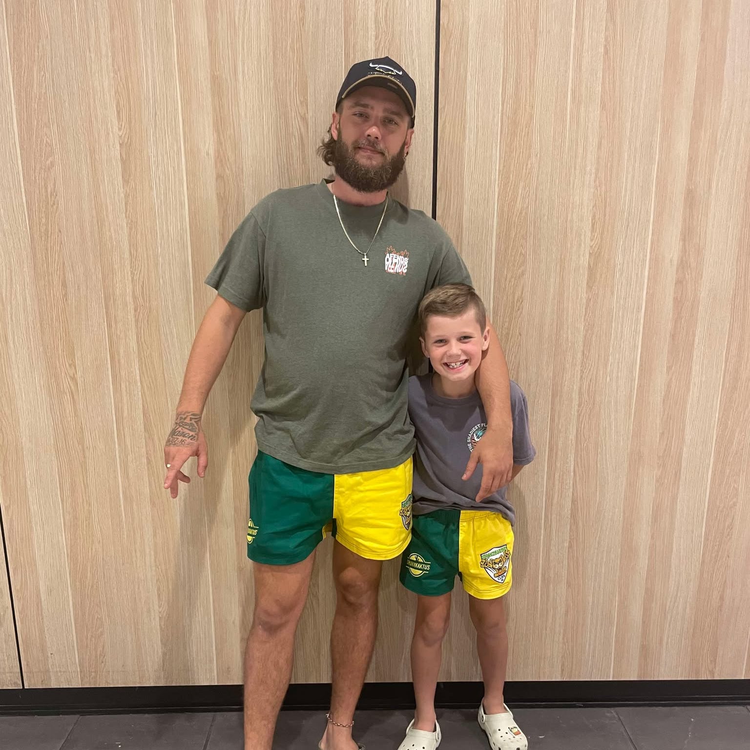 Model wearing green gold cotton shorts in casual outdoor setting