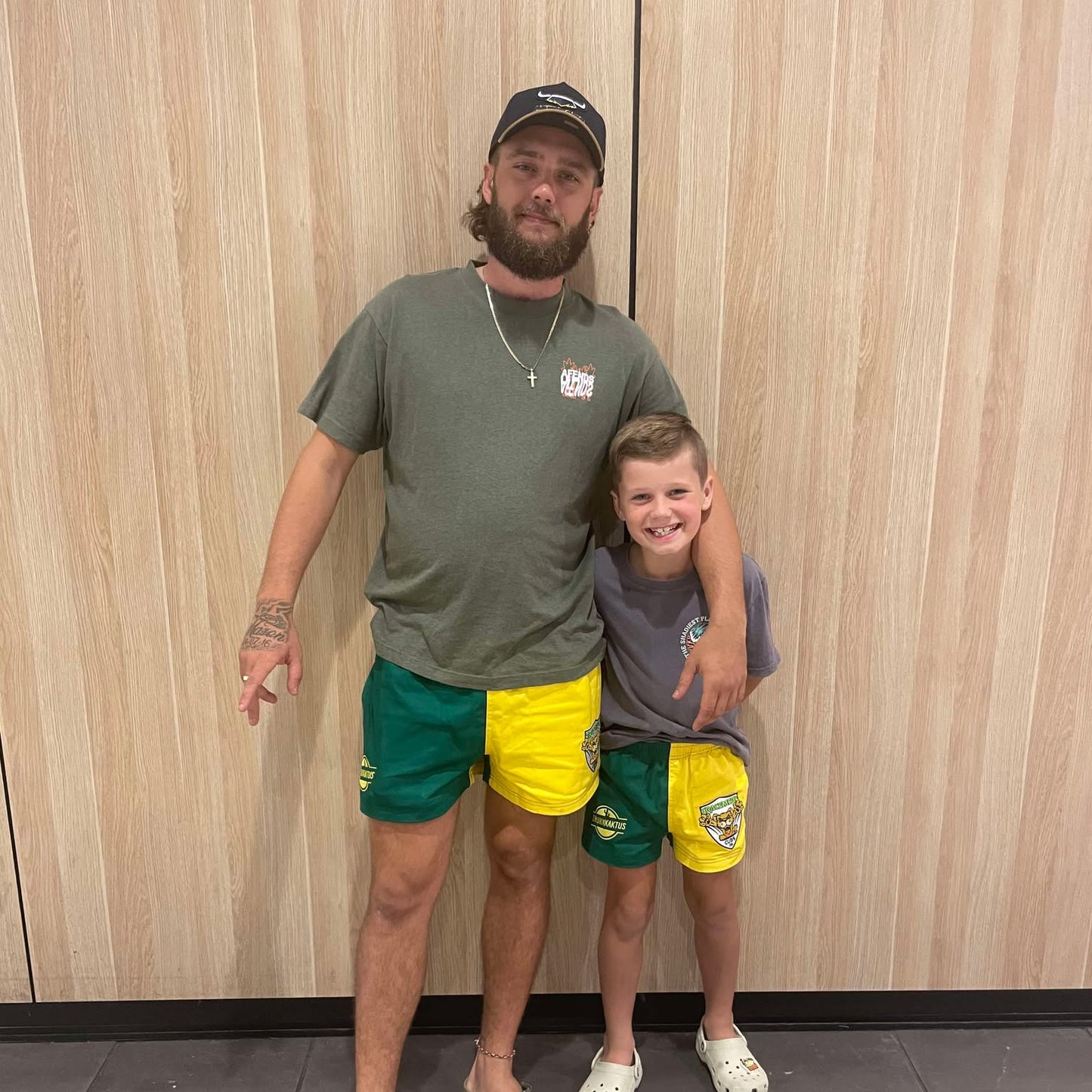 Model wearing green gold cotton shorts in casual outdoor setting