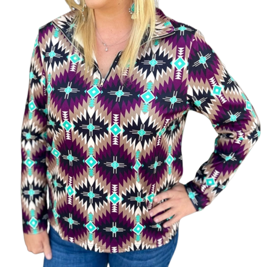 A woman wearing a vibrant Southwestern Aztec Pullover Sweatshirt with a mix of purple, black and blue colors, paired with blue jeans.