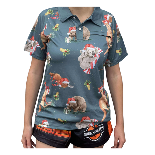 Woman wearing a lightweight green ladies’ Sun Shirt with breathable side panels, zip pocket, and buttoned collar – Aussie Christmas style.