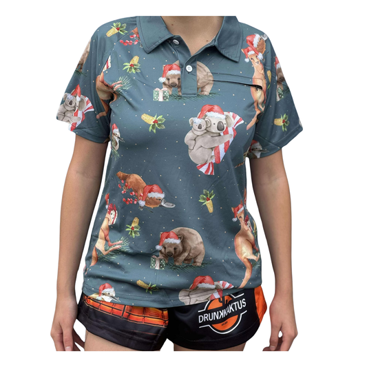 Woman wearing a lightweight green ladies’ Sun Shirt with breathable side panels, zip pocket, and buttoned collar – Aussie Christmas style.